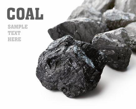 Coal lumps spilled on white background with copy space