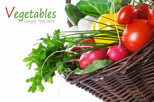 Composition with raw vegetables, green leaves and wicker basket isolated on white background. Copy space 