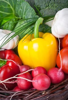 Composition with raw vegetables in a wicker basket. Closeup