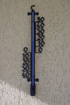 A thermometer on the wall of a house