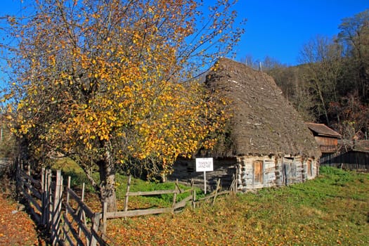 A little wooden cottage with board fence