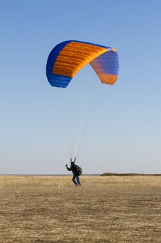 A male paraglider pilot prepares for flight