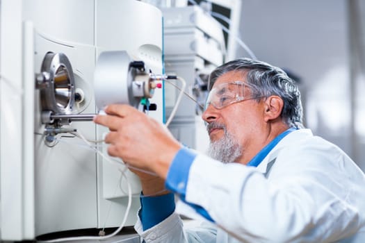 Senior male researcher carrying out scientific research in a lab (shallow DOF; color toned image)