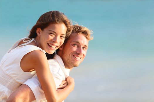 Multiracial people: Happy couple piggybacking cheerful on beach during summer holidays vacation.