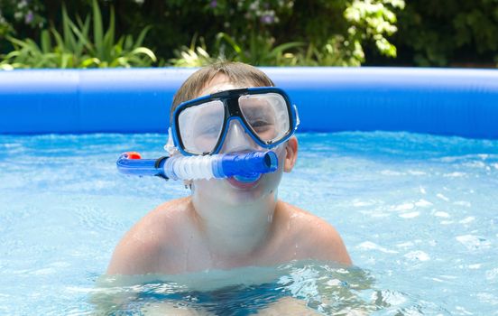 Boy in garden pool with mask and snorkel