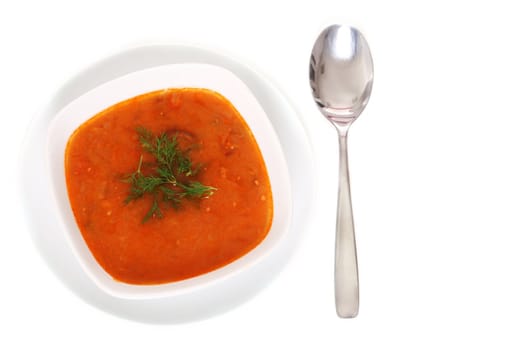 Image of bowl of hot red soup and silver spoon isolated on white background