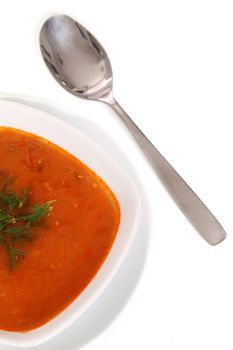 Image of bowl of hot red soup and silver spoon isolated on white background