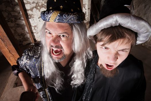 Caucasian father and son dressed as wizards shouting