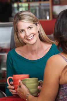 Smiling mature white woman sitting with friend in restaurant