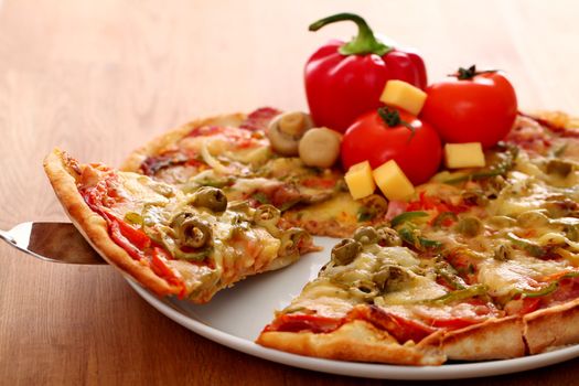 Fresh italian pizza in plate on a wooden surface