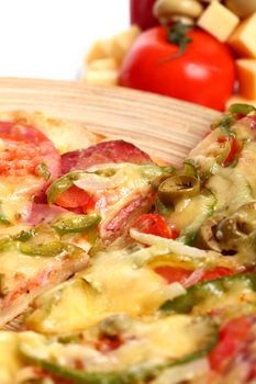 Image of sliced pizza in a plate and vegetables isolated over white background