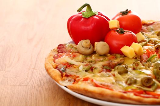 Fresh italian pizza in plate on a wooden surface