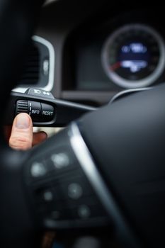 Modern car interior - driver pressing a button, using the car computer