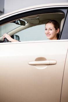 Pretty young woman driving her new car