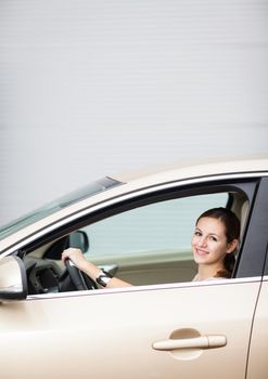 Pretty young woman driving her new car