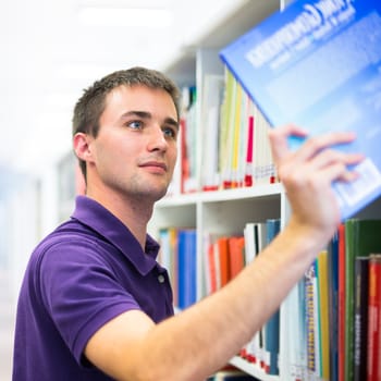 Handsome college student in library (shallow DOF; color toned image)