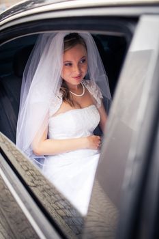 Portrait of a beautiful young bride waiting in the car on her way to the wedding ceremony