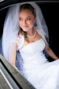 Portrait of a beautiful young bride waiting in the car on her way to the wedding ceremony