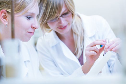 female researchers carrying out research together in a chemistry lab/research center (color toned image; shallow DOF)