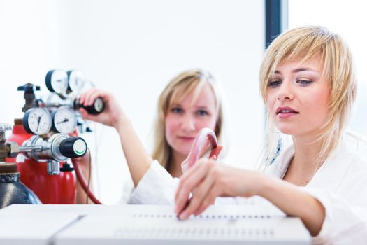 Two female researchers working in a laboratory (color toned image)