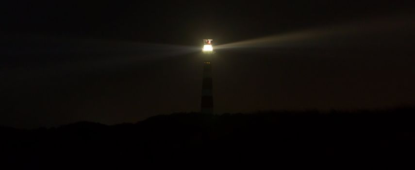 Lighthouse in the dark on the dutch isle of Ameland, Holland, room for text