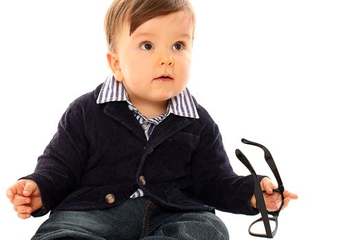 Beautiful serious little boy in a coat and jeans isolated over white background