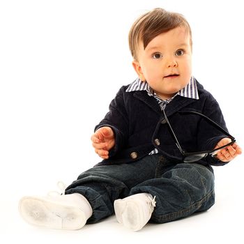 Beautiful serious little boy in a coat and jeans isolated over white background