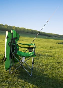 Chair fisherman and a fishing rod on the shore of the lake. Preparation for fishing