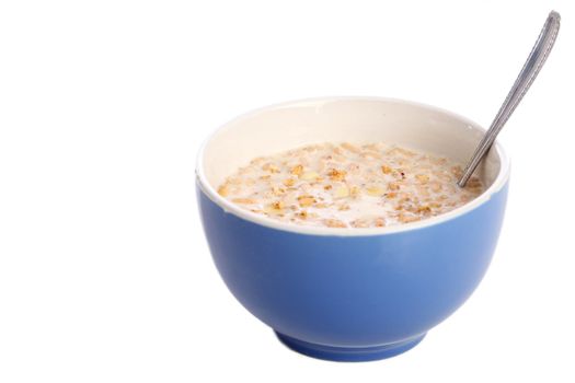 Image of blue bowl with spoon filled with healthy muesli and milk isolated on white background