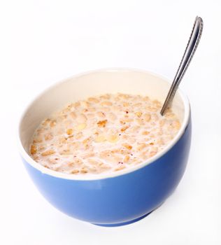 Image of blue bowl with spoon filled with healthy muesli and milk isolated on white background