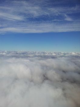 Aerial view of white clouds from airplane window.