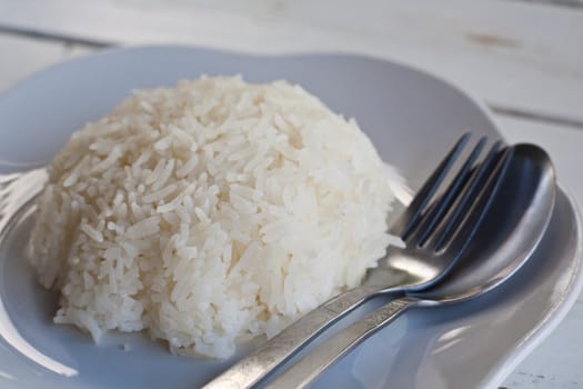 Rice on a white plate with utensils.