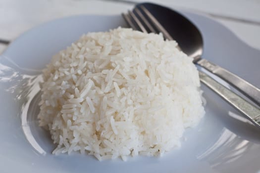 Rice on a white plate with utensils.