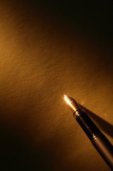 Closeup of stylish ink pen on paper surface with beam of light