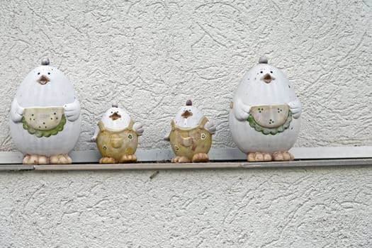 Four-part chicken-shaped colored pottery on the house wall