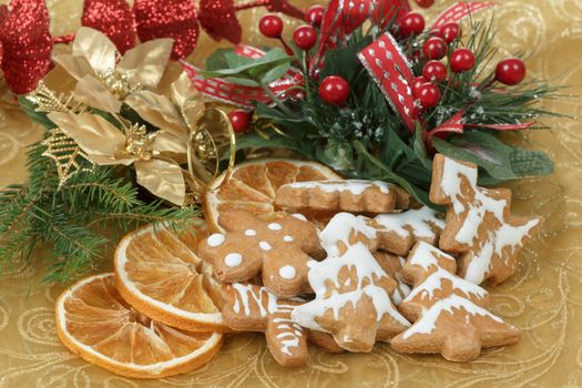 christmas background with needles. orange slices and gingerbreads on red