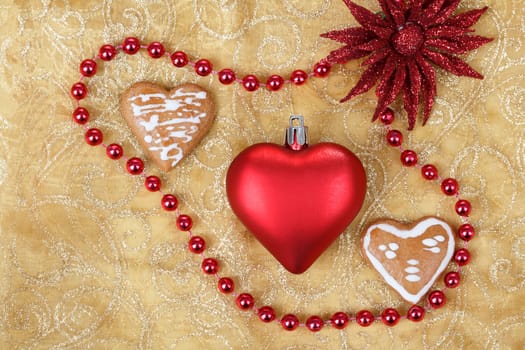 red heart with jewelery and gingerbread on christmas table cloth