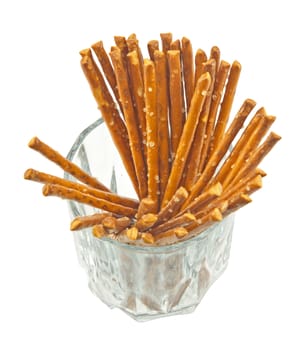 A handful of salty sticks in a glass isolated on white background