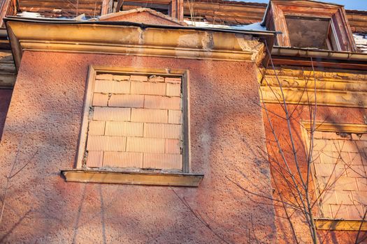 Abandoned house sealed with bricks in winter