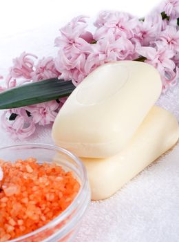 Aromatic bath salt, natural herbal soap and hyacinth on a white towel