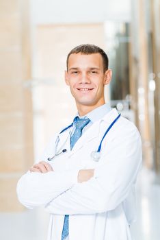 Portrait of a doctor standing in the office and crossed his arms