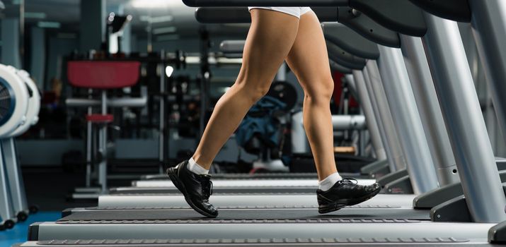 woman running on a treadmill in a fitness club, sport in the fitness club