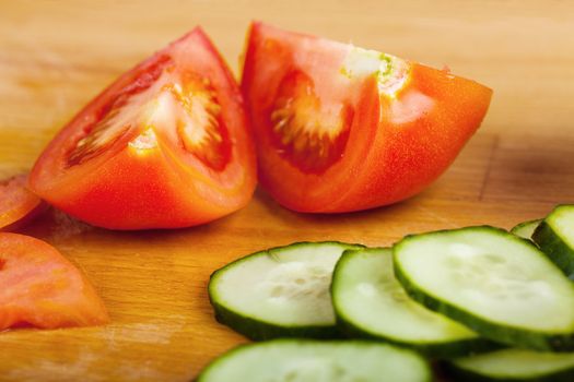 Vegetables (tomato and cucumber) on a wooden table