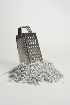 Cheese grater with paper shreds at the base