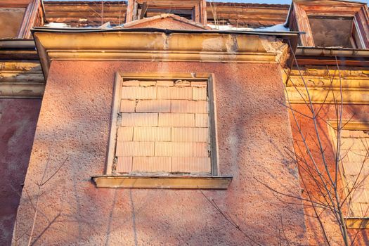 Abandoned house sealed with bricks in winter