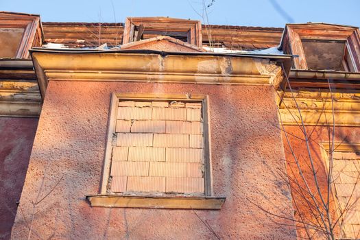 Abandoned house sealed with bricks in winter