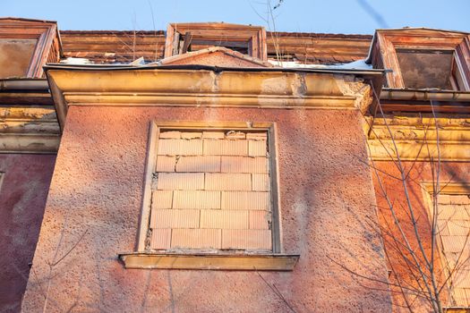 Abandoned house sealed with bricks in winter