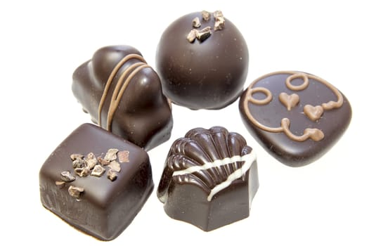 Dark Chocolate Assortment with Truffles Heart Swirls Nuts Isolated on White Background