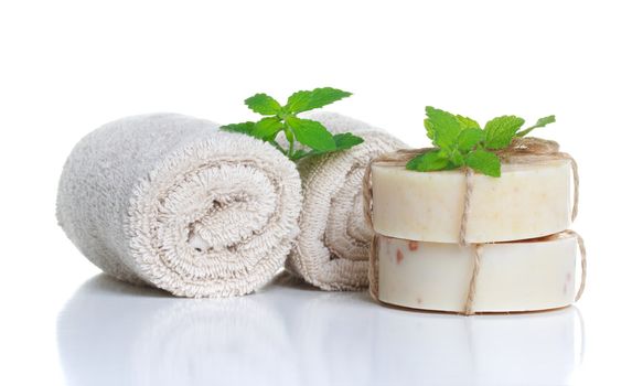 Spa bath soap and rolled towels with mint leaves