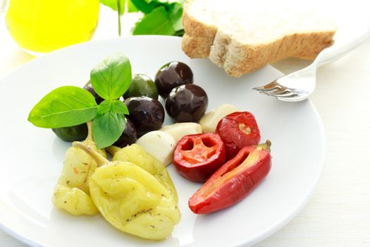 Assorted Olives and Peppers on a White Plate
